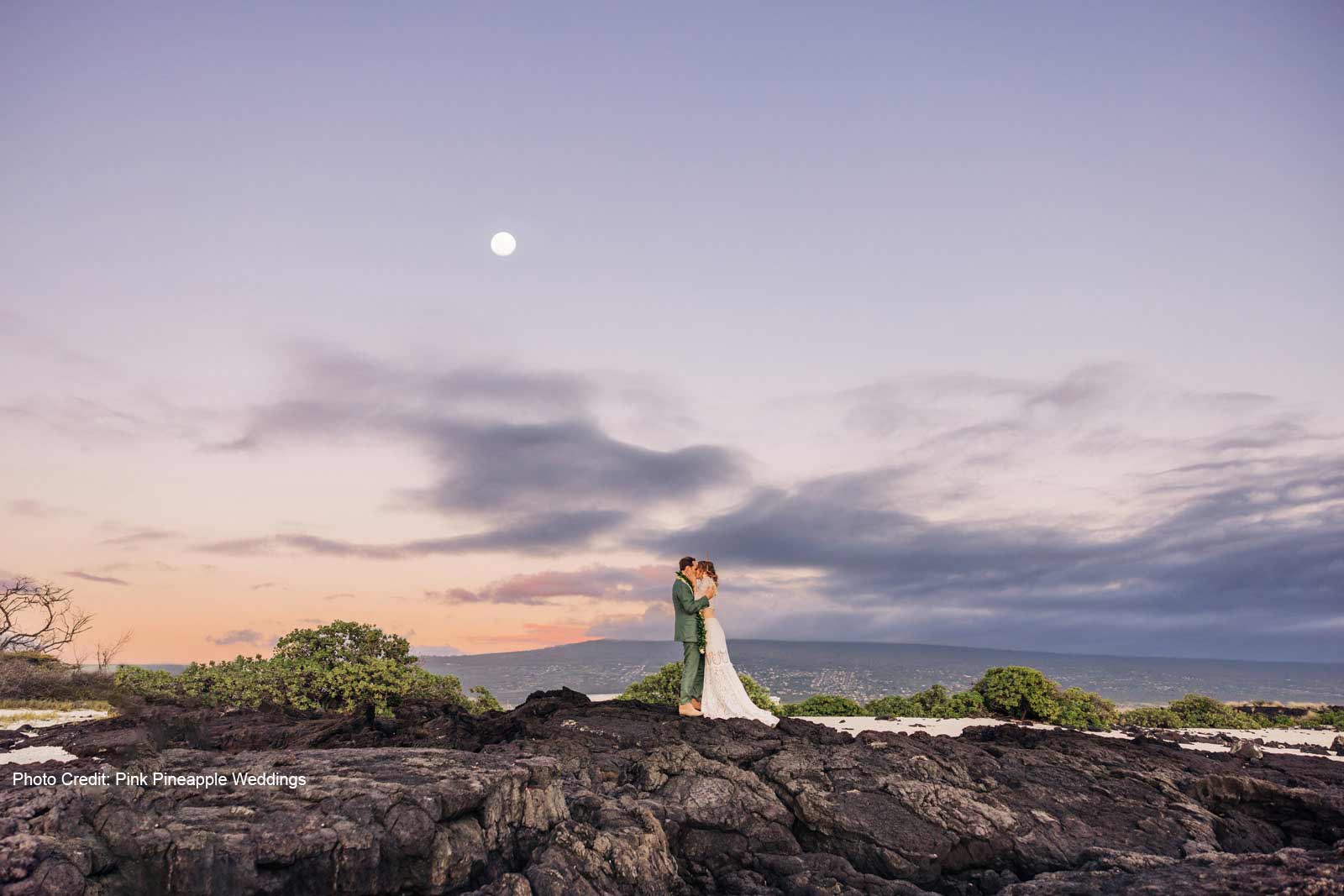 Couple on the Rocks in Front of Hualalai Mountain
