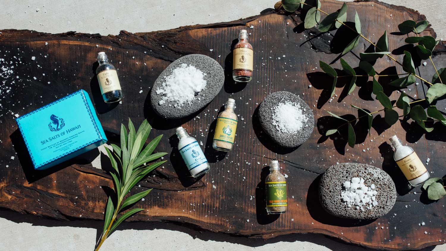 Sea salt bottles arranged on a wooden board