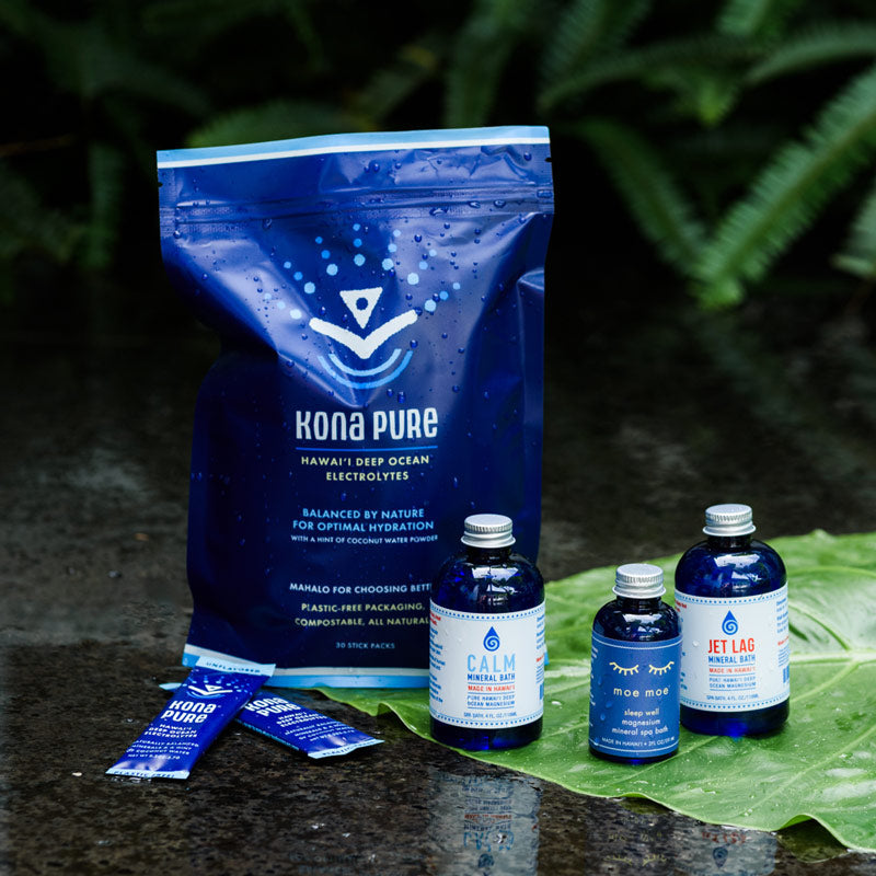 Kona Pure Deep Ocean Electrolytes with 3 bottles of assorted magnesium products on a leaf with a natural background.