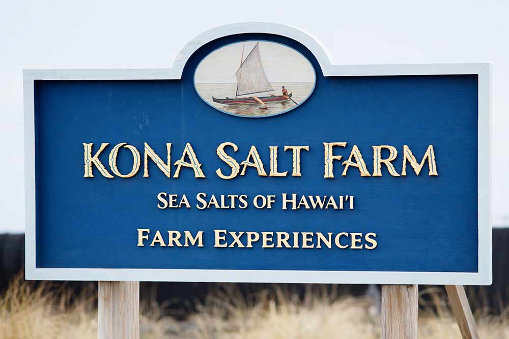Kona Salt Farm sign with text and logo on a blue background