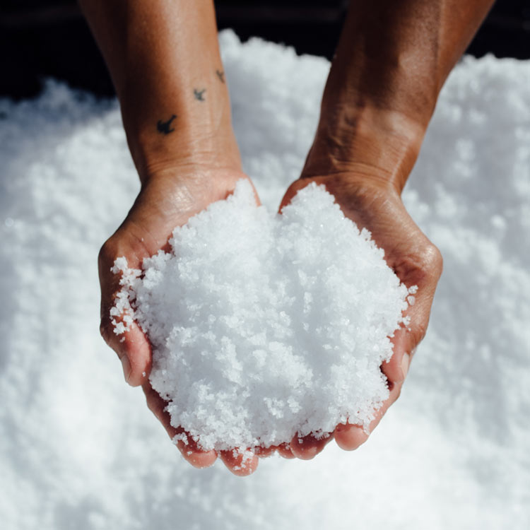 Two hands holding pure Konan Hawaiian sea salt